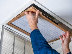 A family in a living room with an air conditioning vent, showing comfort during humid summer weather.